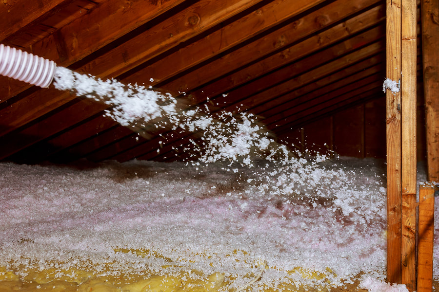 worker spraying bubble insulation in the floor